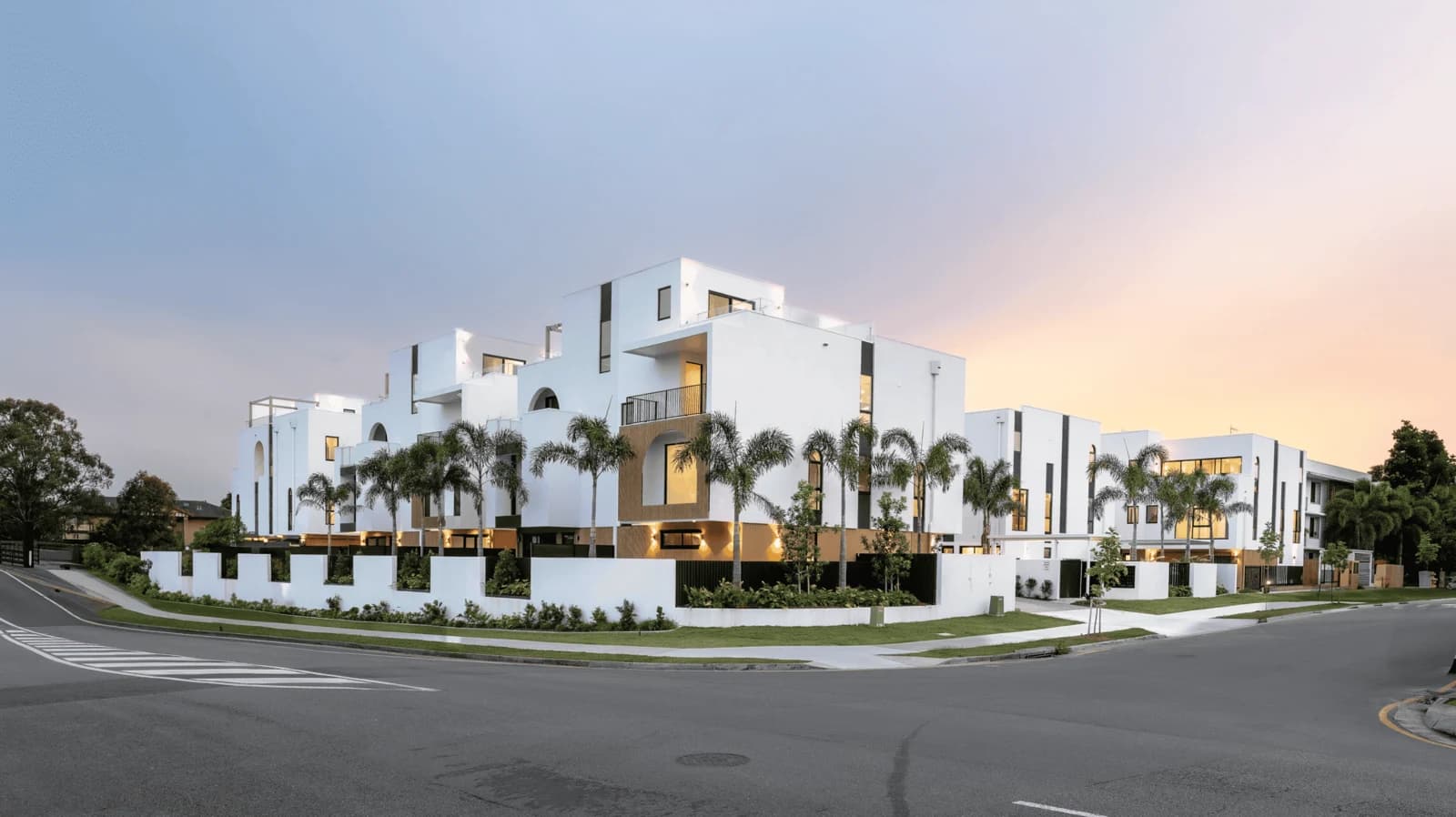 White townhouses on a landscaped street corner in Bundall, Gold Coast