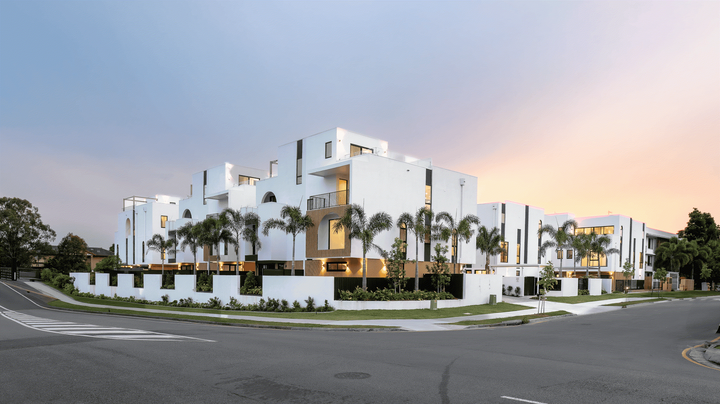 White townhouses on a landscaped street corner in Bundall, Gold Coast