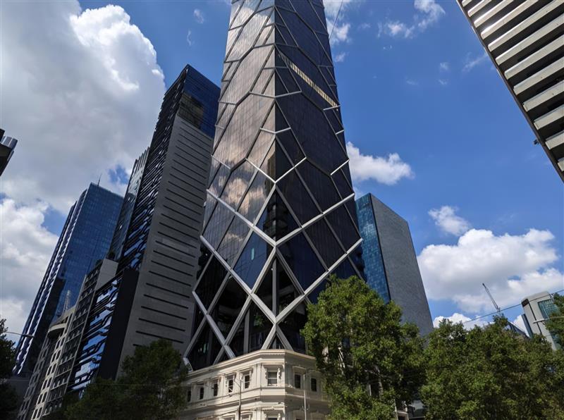 High-rise tower with a geometric facade above a heritage building in CBD, Melbourne
